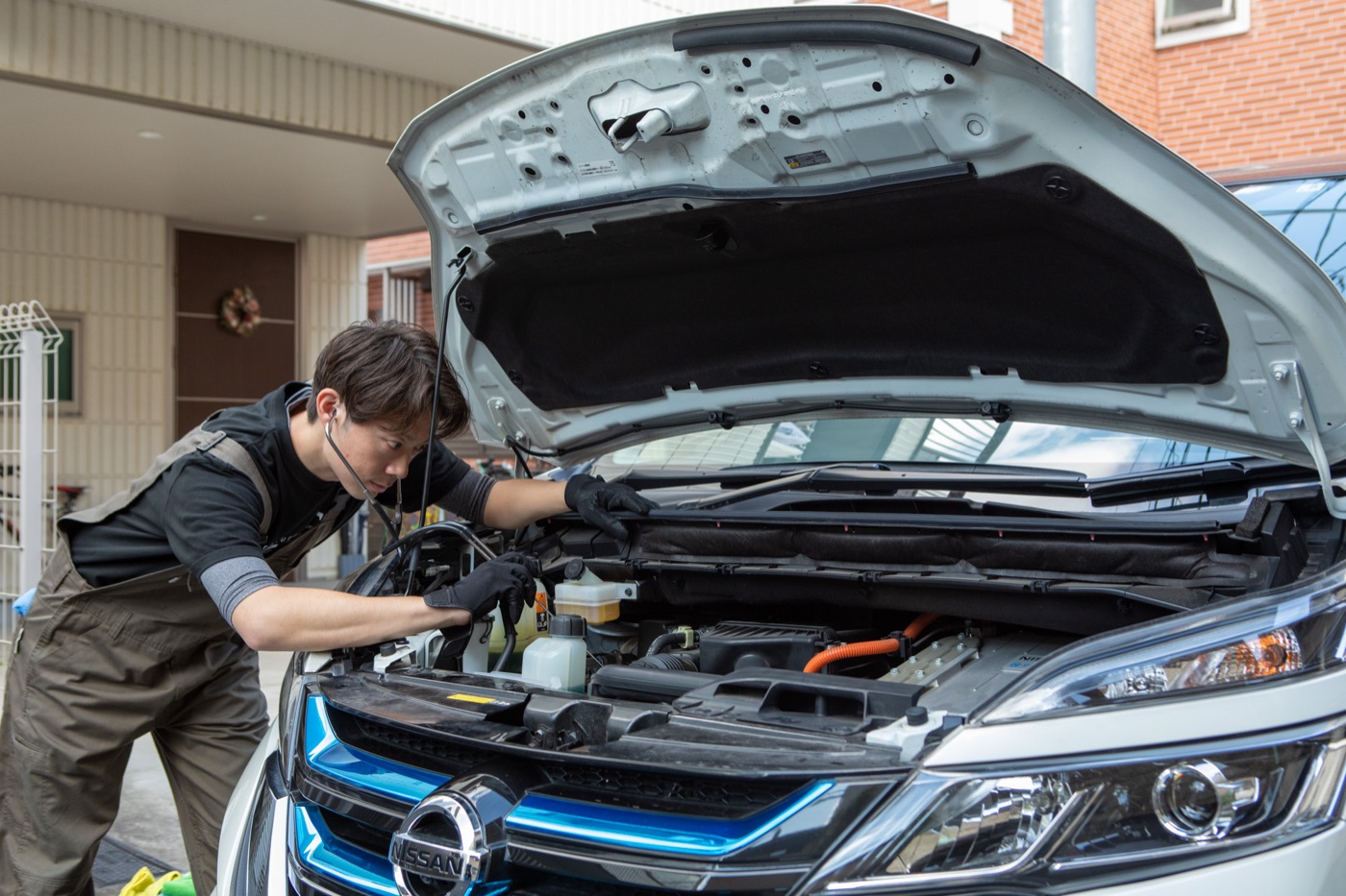 ご自宅の駐車場で点検作業をする整備士